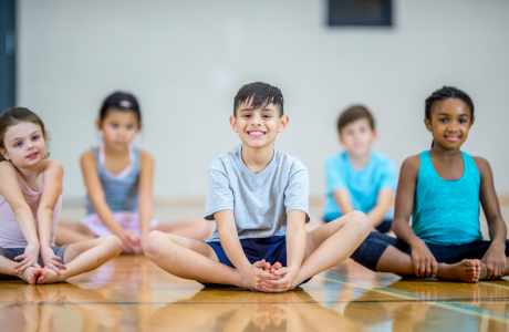 Children doing yoga in a gymnasium