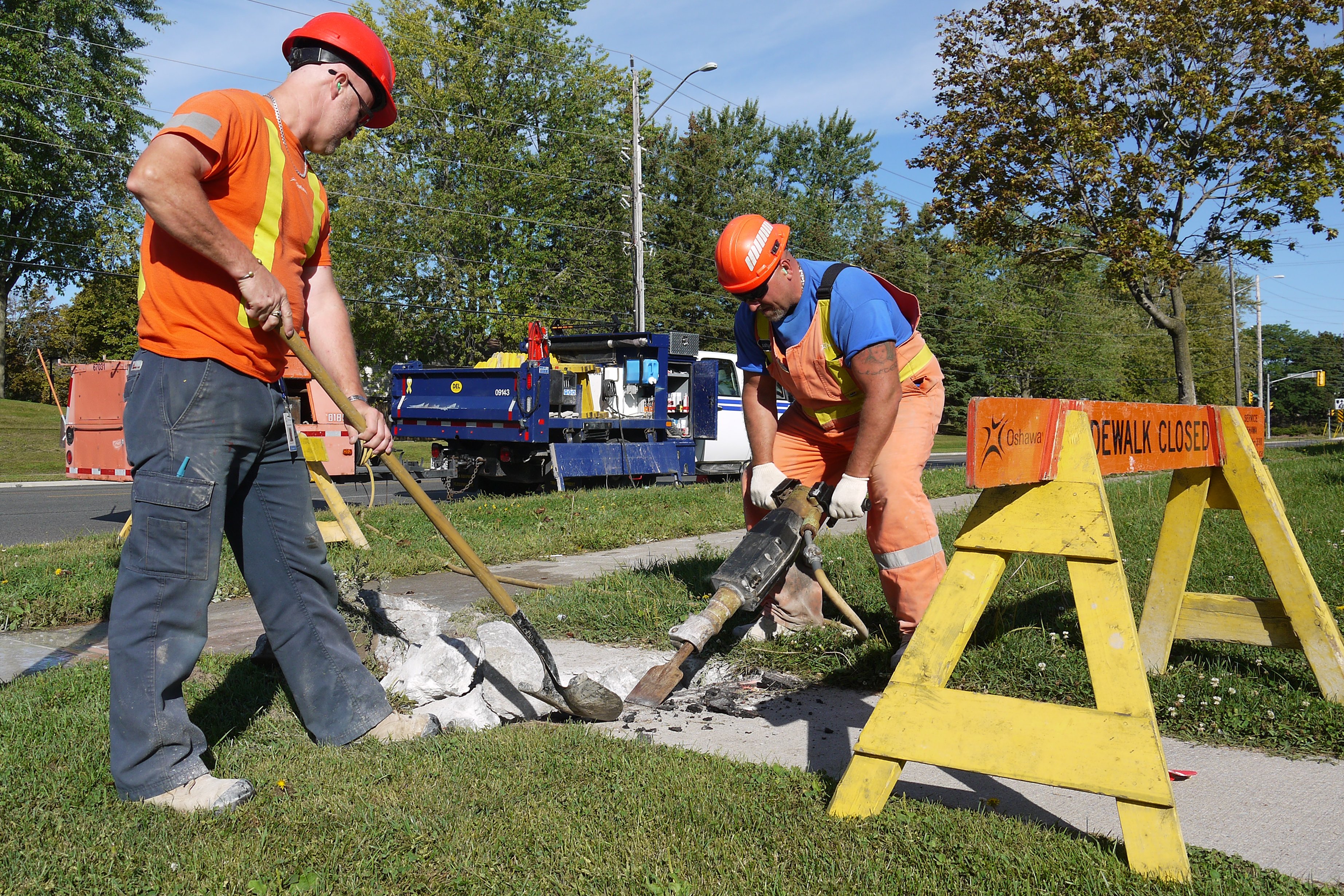 Two City staff at work replacing elements of a City sidewalk