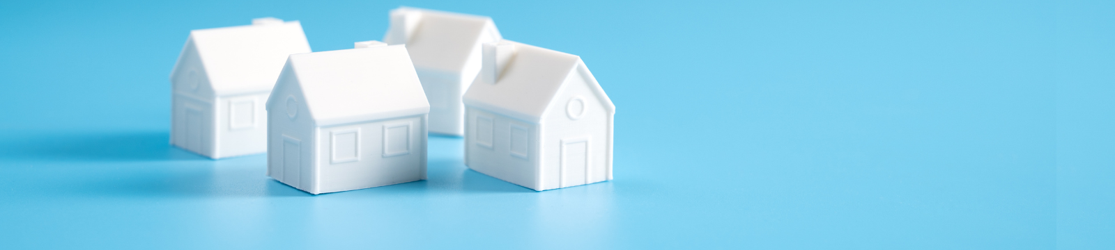 four white houses on a blue background.