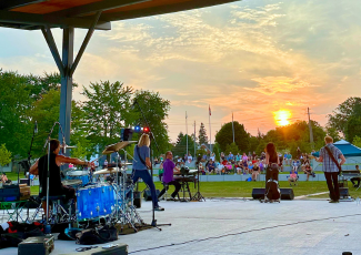 reverse photo of band playing on stage with audience