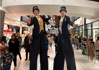 two stilt walkers wearing New Year's outfits