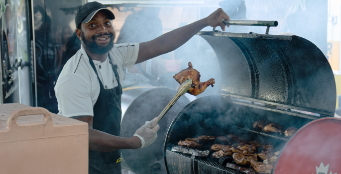 man barbequing chicken