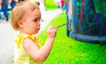 A toddler painting on a bus