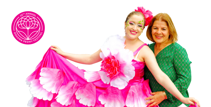 two women posing together, one is dressed in Peony themed dress with glittery makeup and the other is in a green sweater, both are smiling