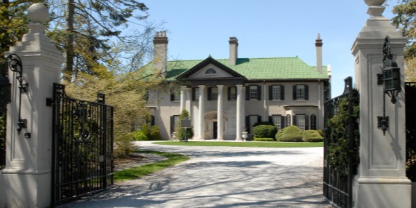 Front view of Parkwood Estate building, with greenery surrounding, and architecture of beige stone and green roof