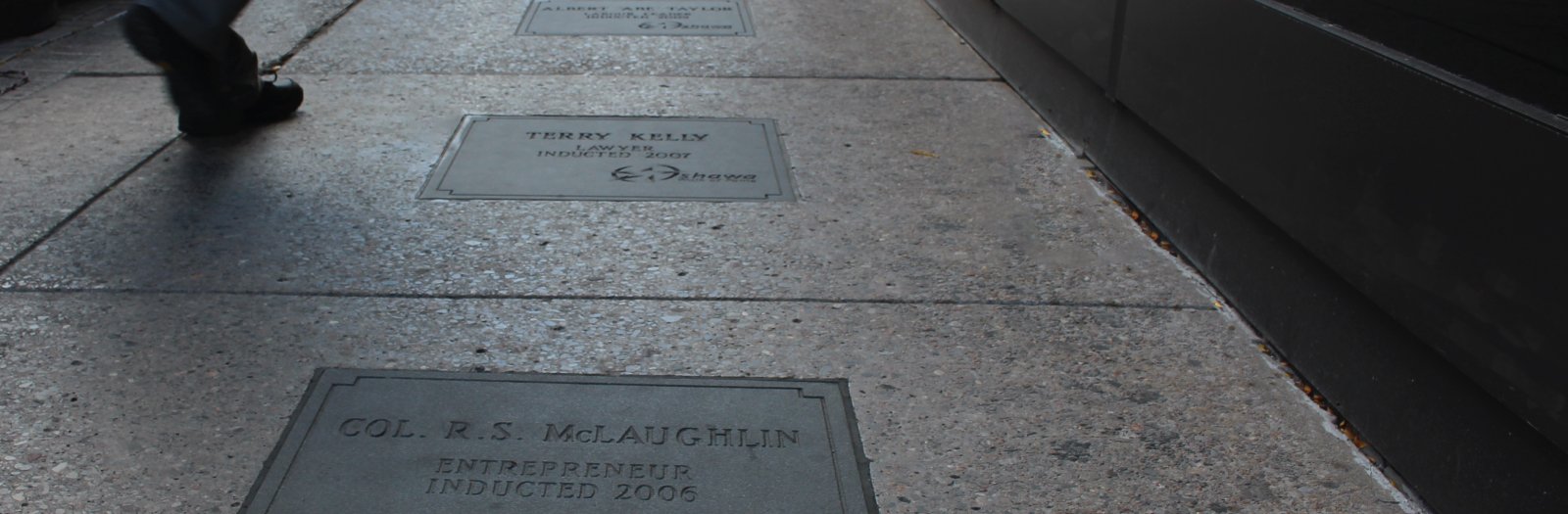 a pair of feet walking across the pavement in downtown Oshawa's Walk of Fame